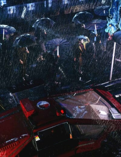 Nighttime urban scene with people holding umbrellas walking in the rain under city lights.