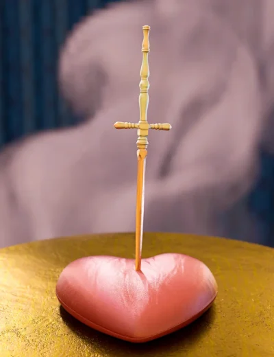 Pink heart pierced by wooden sword on gold surface symbolizes love, pain, and sacrifice.